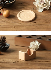 Macro view of walnut wood coasters and rectangular holder set on a rustic desk