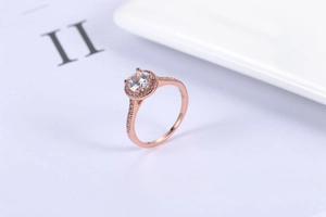 Macro view of rose gold halo ring showing pavé diamonds and circular center stone