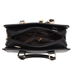 Top view of black textured leather handbag with gold zippers and organized interior compartments