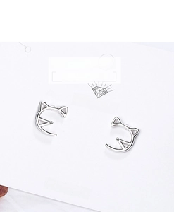 Close-up of minimalist silver cat ear stud earrings on a white jewelry display card