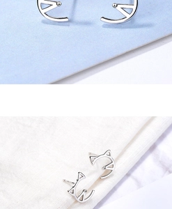 Macro detail of silver cat ear stud earrings with minimalist hollow-out design