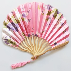 Traditional Japanese style pink silk folding fan with floral patterns and bamboo ribs