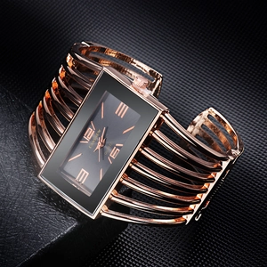 Detail of rose gold bangle watch with rectangular black dial and hollow cuff design
