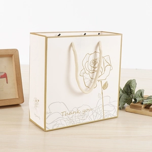 Elegant white paper gift bag with gold rose patterns and 'Thank You' text detail