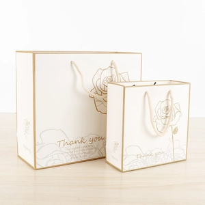 Elegant white paper gift bags with gold rose patterns and Thank You text in two sizes