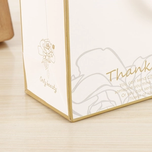 Detail of elegant gift bag with gold rose pattern and reinforced bottom folding craft