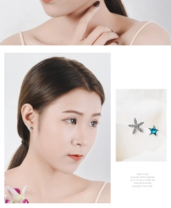 Macro detail of asymmetric blue star earrings with white crystals for women