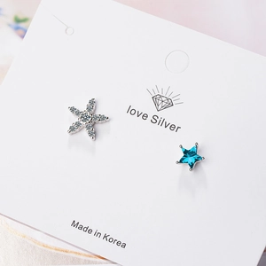 Asymmetric blue star and silver snowflake stud earrings for women on a white jewelry card