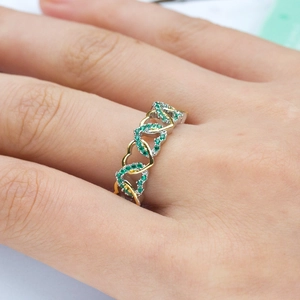 Elegant two-tone interlaced heart ring with sparkling green zircon stones for women