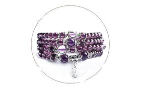Detail of multi-layer wrap bracelet featuring purple glass beads and silver metal spacers