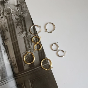 Macro detail of S925 sterling silver hallmarked hoop earrings in gold and silver finishes