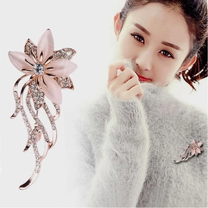 Elegant rose gold flower brooch with pink opal petals and pearls on a grey sweater