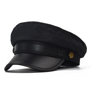 Detail of black military cap featuring mixed fabric texture and a faux leather brim