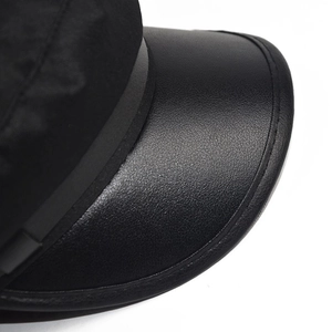 Detail shot of the faux leather brim and fabric stitching on this black newsboy hat