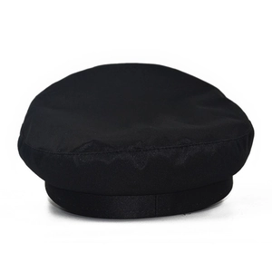 Flat top black cotton beret showing detailed fabric texture and seamless stitching