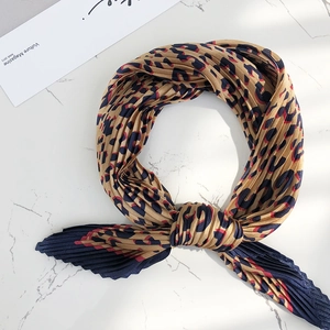 Close up of pleated leopard print silk scarf detail, elegant neckerchief texture display.