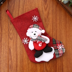 Close-up of red burlap Christmas stocking with plush bear and snowflake embroidery detail
