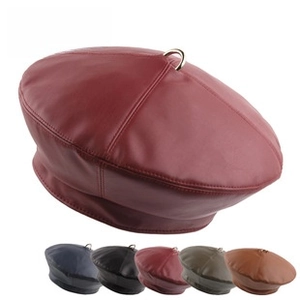 Détail du béret en similicuir mat avec anneau métallique et options de couleurs variées