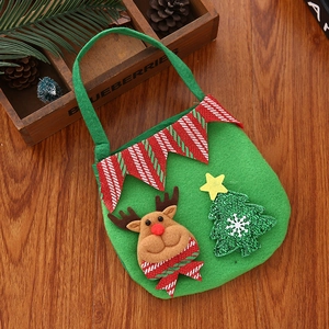 Detail of green Christmas gift bag featuring 3D reindeer and snowflake tree on wood background