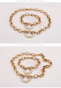 Detail of gold chain link set with circular pendants encrusted with baguette-cut zircons