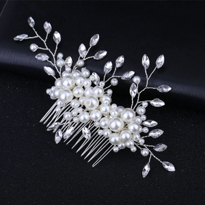 Close-up of handmade bridal hair comb with pearls and rhinestones on black leather background