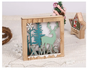 Close-up of wooden XMAS lighted box with reindeer and pine trees forest scene