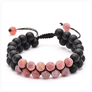 Detail of double-layer braided bracelet with matte black and red cracked agate beads
