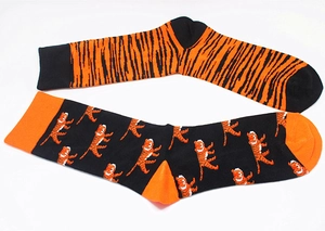 Detail of cotton crew socks featuring orange tiger stripes and cartoon tiger patterns