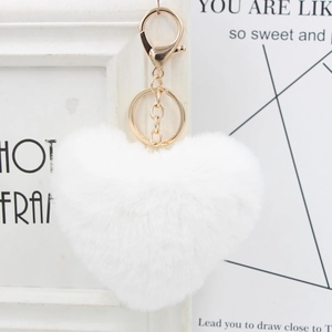 Close-up of a white heart-shaped fluffy faux fur keychain with a gold lobster clasp