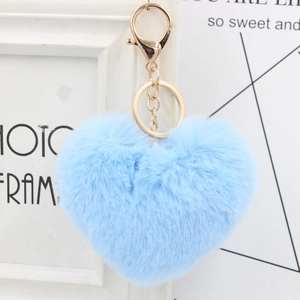 Close-up of a blue heart-shaped fluffy keychain with a golden metal ring and chain