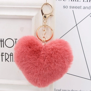 Close-up of a pink heart-shaped plush keychain with a gold metal clasp and chain