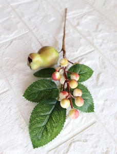 Detail of artificial green fruit and red berries with green leaves for DIY decor