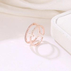 Detail of rose gold double-layered ring with zircon stones and cross motif on silk