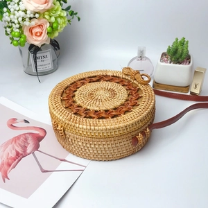 Handcrafted round rattan crossbody bag with brown leather strap in bohemian woven style