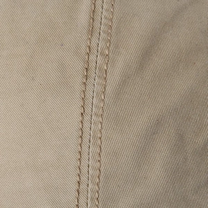 Vue macro du tissu en sergé de coton kaki avec une double couture de renfort de haute qualité