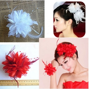 Detail view of bridal feather and mesh flower hair accessories set in white and red colors