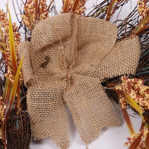 Rustic Thanksgiving wreath with burlap bow, dried wheat stalks and vibrant red berries