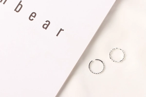 Detail view of silver twisted and wavy S925 sterling silver rings on fabric