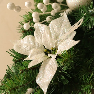 White glitter Christmas flower ornament on a green pine tree for holiday home decoration