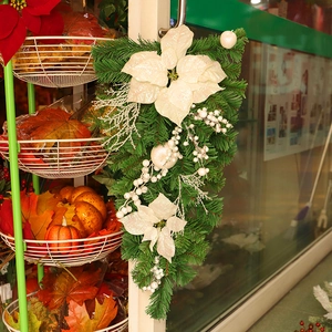 Christmas teardrop swag with white poinsettias, pine needles and berries for door decor