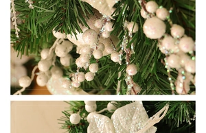 Macro detail of Christmas teardrop swag with white glitter berries and pine needles