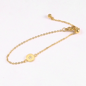 Detailed shot of golden minimalist bracelet with round crystal pendant and lobster clasp