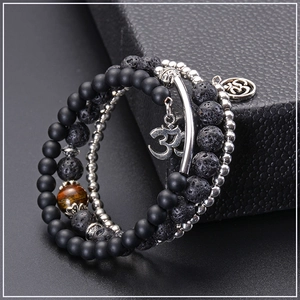 Detail of multi-layer lava stone bracelet with tiger eye bead and Om charms on gift box