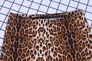 Close-up of leopard print flare pants showing high elastic waistband and animal pattern fabric