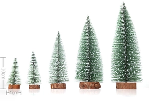 Detailed view of five mini frosted Christmas trees with wooden bases in various sizes