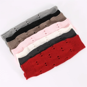Close-up of knit arm warmers in various colors featuring hollow out crochet details