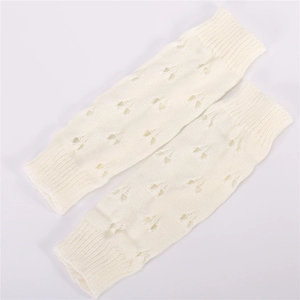 Close-up of cream knit arm warmers showing hollow texture and ribbed cuffs
