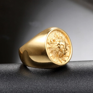 Macro view of detailed lion head relief on a polished gold stainless steel signet ring