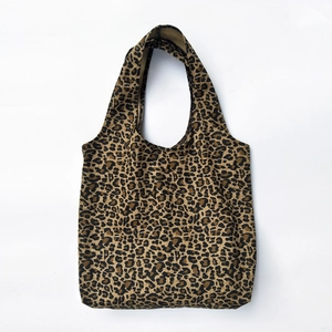 Borsa tote in tela con stampa leopardata e ampi manici su sfondo bianco