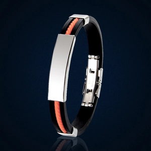 Détail du bracelet en silicone noir et orange avec plaque métallique argentée polie